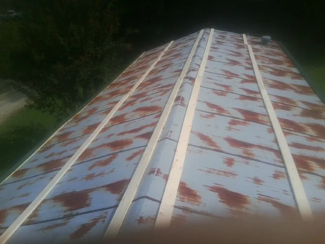 Rusted metal roof panels with new wood purlins before replacement — Storm Damage Roof Repair in Goreville by Roofing Brothers
