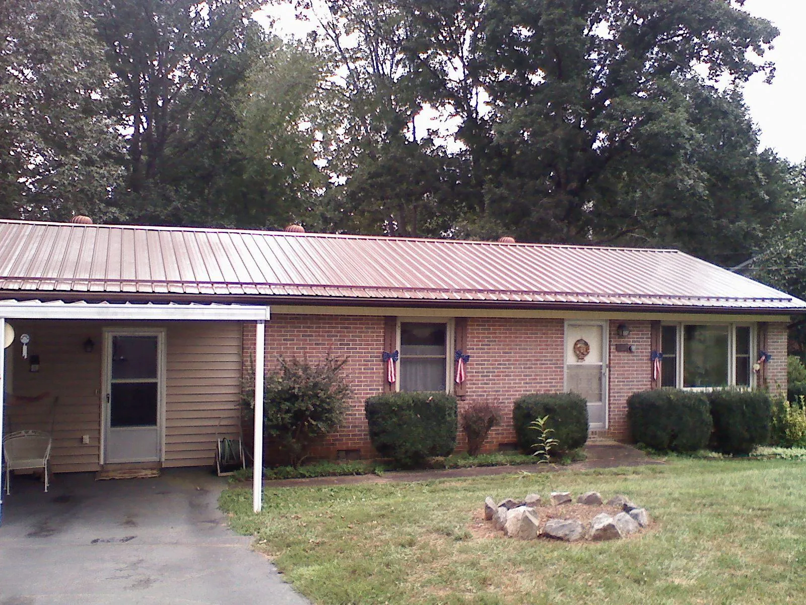 Bronze metal roof and carport on a brick ranch home — Roof Repair work by our crew in Goreville